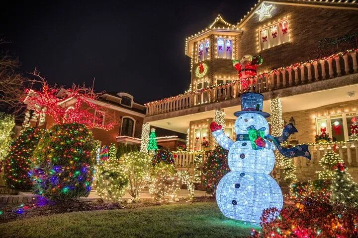 Dyker Heights house covered in Christmas lights with an illuminated snowman in the garden.